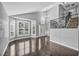 Elegant living room featuring hardwood floors, large windows, and a staircase with iron railing at 4516 Whelk Pl, North Las Vegas, NV 89031