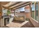 An outdoor kitchen with a stainless steel grill, mini-fridge, and stone counter, excellent for backyard entertaining at 4516 Whelk Pl, North Las Vegas, NV 89031