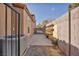 Narrow side yard with a concrete walkway, exterior air conditioning unit, and a block wall fence at 4516 Whelk Pl, North Las Vegas, NV 89031