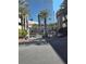 Community entrance with palm trees, lush landscaping, and a glimpse of the city skyline at 4525 Dean Martin Dr # 503, Las Vegas, NV 89103