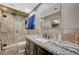 Bathroom with a rainfall shower head, granite counters and dark wood cabinetry at 4625 W Robindale Rd, Las Vegas, NV 89139