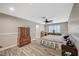 Cozy bedroom with wood-look floors, a large dresser, and a patterned bedspread at 4625 W Robindale Rd, Las Vegas, NV 89139