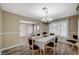 Formal dining room offers wainscoting, a decorative light fixture, and backyard views through sheer curtains at 4625 W Robindale Rd, Las Vegas, NV 89139