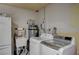 Functional laundry room with washer, dryer, utility sink, water heater, and additional storage space at 4625 W Robindale Rd, Las Vegas, NV 89139
