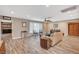 Comfortable living room with wood-look floors, ceiling fan, and sliding glass doors out to the back at 4625 W Robindale Rd, Las Vegas, NV 89139