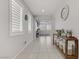 Bright hallway featuring neutral walls, tile flooring, large windows, and decorative furniture at 4733 Cactus Sun Ln, North Las Vegas, NV 89031