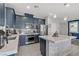 Modern kitchen featuring navy cabinets, stainless appliances, and a large center island with counter seating at 4733 Cactus Sun Ln, North Las Vegas, NV 89031