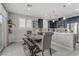 Bright kitchen with stainless steel appliances, blue cabinets, modern countertops, and dining area at 4733 Cactus Sun Ln, North Las Vegas, NV 89031