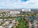 Aerial view of a Los Prados golf course, with a view of a lake, lush trees, and the surrounding neighborhood at 5209 Rim View Ln, Las Vegas, NV 89130