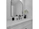 Stylish bathroom with an arched mirror, flower decor, and modern vanity at 5209 Rim View Ln, Las Vegas, NV 89130