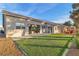 Back exterior view of the home highlighting the lawn, patio, and outdoor seating at 5209 Rim View Ln, Las Vegas, NV 89130