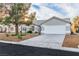 Single-story house featuring desert landscaping, mature tree, a spacious driveway, and attached two-car garage at 5209 Rim View Ln, Las Vegas, NV 89130