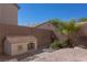 Fenced backyard with a brick-paved area features desert landscaping and a cute dog house at 53 Hoke Edward Ct, North Las Vegas, NV 89031