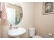 Cozy bathroom with a pedestal sink, toilet, and decorative mirror at 53 Hoke Edward Ct, North Las Vegas, NV 89031