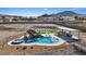 Aerial view of backyard featuring a rock waterfall pool, hot tub, outdoor kitchen, and pristine landscaping at 541 Patti Ann Woods Dr, Henderson, NV 89002