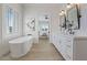 Bright bathroom features a soaking tub, wood floors and double vanity with contemporary fixtures at 541 Patti Ann Woods Dr, Henderson, NV 89002