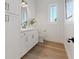 Elegant bathroom with wood-look floors, white cabinetry, and wainscoting at 541 Patti Ann Woods Dr, Henderson, NV 89002