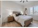 Bedroom with neutral tones, ceiling fan, a decorative mirror, and natural light to create a calming space at 541 Patti Ann Woods Dr, Henderson, NV 89002