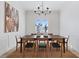 Formal dining room with modern chandelier, wainscoting, neutral tones, and ample seating at 541 Patti Ann Woods Dr, Henderson, NV 89002