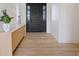 Bright entryway featuring wood floors, modern console table, and decorative sconces leading to the front door at 541 Patti Ann Woods Dr, Henderson, NV 89002