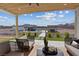 Inviting covered patio showcasing comfortable seating with a view of the pool, waterfall, and outdoor dining area at 541 Patti Ann Woods Dr, Henderson, NV 89002