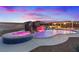 Backyard view of pool, hot tub, and waterfall, with outdoor kitchen under a colorful sky at 541 Patti Ann Woods Dr, Henderson, NV 89002