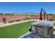 Beautiful backyard with artificial grass, desert landscaping, and a built-in barbeque for outdoor enjoyment at 5528 Eleganza Ave, Pahrump, NV 89061