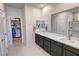 Bathroom featuring double sinks, a large mirror, and access to a walk-in closet and shower at 5528 Eleganza Ave, Pahrump, NV 89061