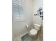 Compact powder room featuring a modern toilet, a decorative window, and neutral decor at 5528 Eleganza Ave, Pahrump, NV 89061