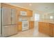 Kitchen area with a stainless steel refrigerator, tile floors, oven and wood cabinets at 5989 Sierra Medina Ave, Las Vegas, NV 89139