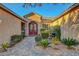 Charming front entrance showcasing a red door, beautiful landscaping and paved walkway at 6156 Twilight Cove Cir, Las Vegas, NV 89131