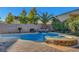 Lush backyard features a sparkling pool, rock waterfall, and spa for ultimate relaxation at 6156 Twilight Cove Cir, Las Vegas, NV 89131