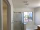 Bright bathroom featuring a glass shower, a soaking tub, and a window view to the backyard at 6425 W Haleh Ave, Las Vegas, NV 89141