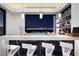 Modern bar area with a quartz countertop and barstool seating overlooking the city skyline at 667 Solitude Rock Ct, Henderson, NV 89012