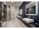 Luxurious bathroom featuring double sinks, marble counters, and a glass-enclosed shower at 667 Solitude Rock Ct, Henderson, NV 89012