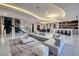 Large living room with marble floors, modern lighting, and a gray sectional is perfect for entertaining guests at 667 Solitude Rock Ct, Henderson, NV 89012