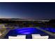 Rooftop pool and deck area with night view of city lights and mountain range at 667 Solitude Rock Ct, Henderson, NV 89012