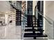 Staircase with a glass railing and wine display at 667 Solitude Rock Ct, Henderson, NV 89012