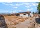 Wide view of the spacious backyard with a covered patio, solar panels, and block wall fence at 6731 Fallona Ave, Las Vegas, NV 89156