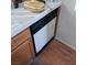 Close-up of a dishwasher with a wood cabinet surround and tile countertops at 6903 Wineberry Dr, Las Vegas, NV 89119