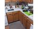 Compact kitchen with wood cabinets, tile countertops, and basic appliances at 6903 Wineberry Dr, Las Vegas, NV 89119