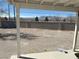 Covered patio area with views of a large, undeveloped backyard and distant mountains at 7133 Tropical Island Cir, Las Vegas, NV 89129