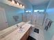 Bright bathroom featuring a double sink vanity and a shower-tub combo with sliding glass doors at 720 Florida St, Pahrump, NV 89048