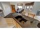 Bright kitchen island with stainless steel faucet, granite countertops, and adjacent dining area at 720 Florida St, Pahrump, NV 89048