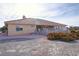 Exterior view of the rear of a house showcasing a covered patio with a brick retaining wall at 720 Florida St, Pahrump, NV 89048