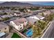 An aerial view showcasing a private backyard oasis, complete with a pool, lush turf, and mountain backdrop at 7411 Zonal Ave, Las Vegas, NV 89131