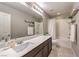 Well-lit bathroom featuring a modern vanity, a large mirror, and a shower-tub combination at 7411 Zonal Ave, Las Vegas, NV 89131