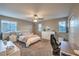 Bright bedroom showcases neutral walls, two sunny windows, a ceiling fan, and white furniture at 7411 Zonal Ave, Las Vegas, NV 89131