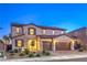 Beautiful two-story home featuring a brick driveway, a three-car garage, and manicured landscaping at 7411 Zonal Ave, Las Vegas, NV 89131