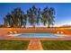 Backyard pool featuring sun loungers and string lights on the wall, set against a backdrop of lush greenery at 7411 Zonal Ave, Las Vegas, NV 89131